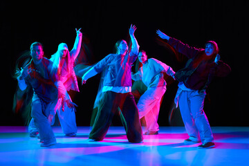 Hip hop dancers performing synchronized street dance with neon lighting and motion blur. Urban...