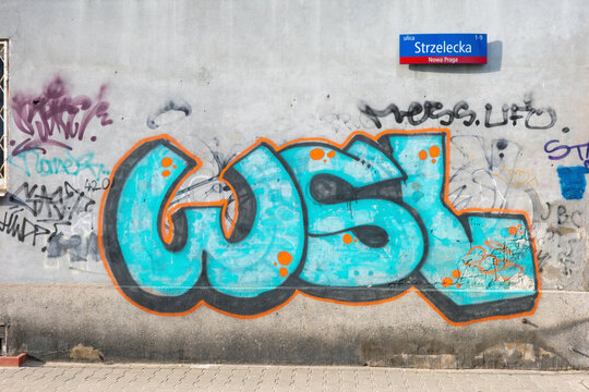 Warsaw, Poland - March 07 2026: A vibrant blue graffiti piece on a gray wall on Strzelecka Street.