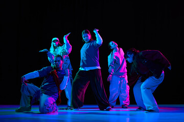 Naklejka premium Hip hop dance performance with neon lighting and crew choreography for music branding, nightlife promotion, entertainment advertising and youth culture marketing campaigns