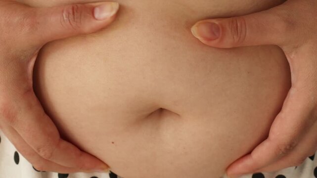 Obese woman hands holding excessive belly fat. Women body fat belly close up