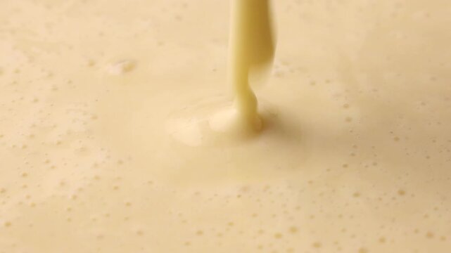 Active and bubbly sourdough starter batter for pancake pouring down close up