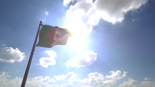 Algeria Flag waving on a Flagpole from a Moving Angle in front of a blue sky with clouds	