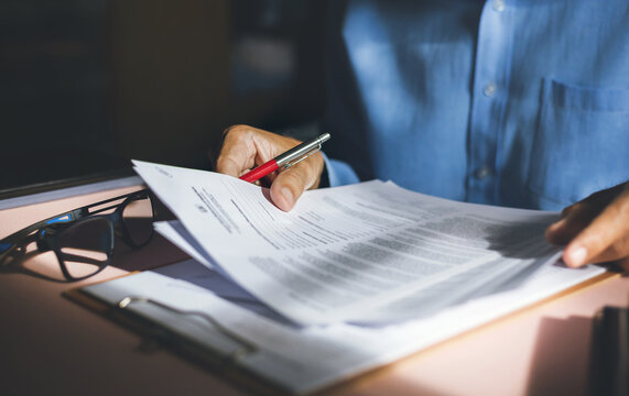 on desk office man reading a contract of investment or insurance, legal agreement before signing, Starting successful partnership with entrepreneur or companie