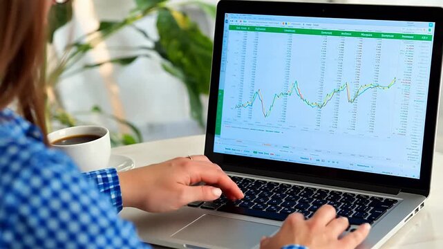 Person working on financial data on laptop