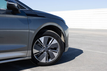 Modern SUV electric car wheel. Close up tires on a road. Detail of car tires on the road. New...