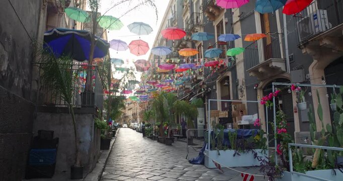 Narrow street with lots of colorful umbrellas hanging, Catania, Sicily, 4k