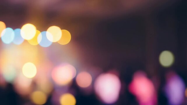 Slow motion pan shot of blurred crowd moving past colorful stage lights at night in indoor concert venue