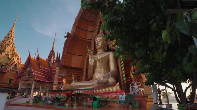Golden Buddha statue at Wat Tham Suea, also known as Tiger Cave Temple, a famous Buddhist temple complex in Kanchanaburi, Thailand, known for its hilltop views and ornate architecture.