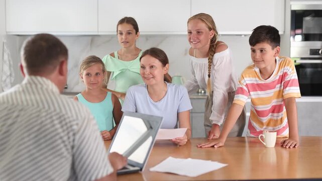 Social services officer visiting woman with multiple children to inform about new benefit 