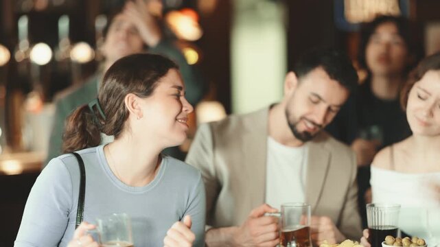 Sports fans react with defeat to changes in failure game. Group of friends hangs out at sports bar, watching teams match, and following progress of game. Video broadcast of match or race is available.