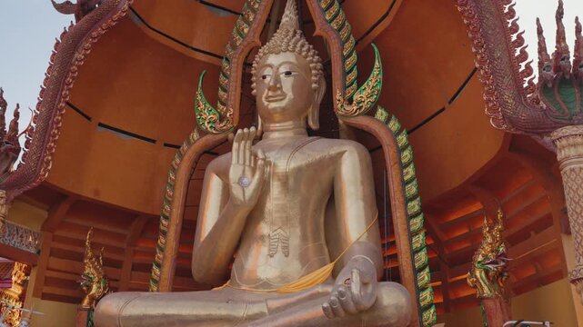 Golden Buddha statue at Wat Tham Suea, also known as Tiger Cave Temple, a famous Buddhist temple complex in Kanchanaburi, Thailand, known for its hilltop views and ornate architecture.