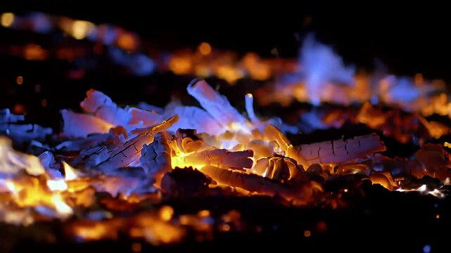 Glowing embers and cool blue flames licking at the charred remains in the dark