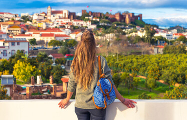 woman tourist enjoying panoramic view of Silves city landscape in Algarve, castle and cathedral in...