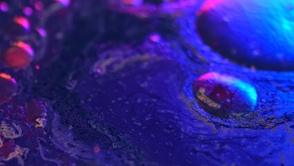 Colorful abstract divorces of oily liquid with neon red, blue and green highlights. Bubbles, stains and shimmering texture create a vivid futuristic background.