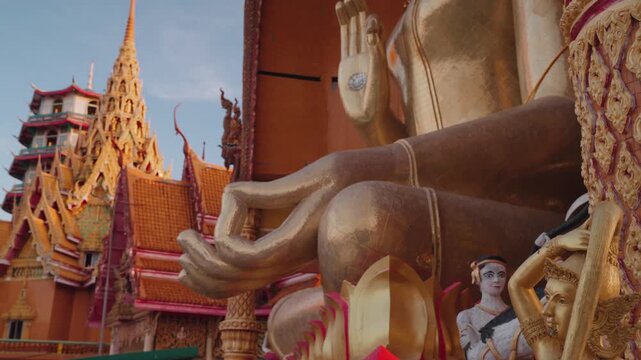 Golden Buddha statue at Wat Tham Suea, also known as Tiger Cave Temple, a famous Buddhist temple complex in Kanchanaburi, Thailand, known for its hilltop views and ornate architecture.
