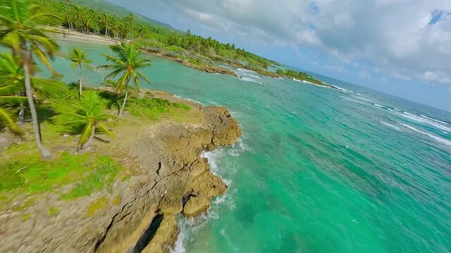Cinematic FPV drone flight over Playa Los Coquitos with pristine white sand and turquoise Caribbean water, tropical coastline and lush palms in Maria Trinidad Sanchez, Dominican Republic.