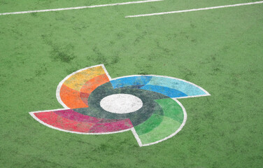 Naklejka premium WBC logo painted on the green grass of a professional baseball stadium