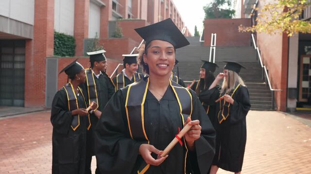Portrait of a proud african american graduate smiling at the camera holding her diploma. Happy multiethnic students celebrating in the background