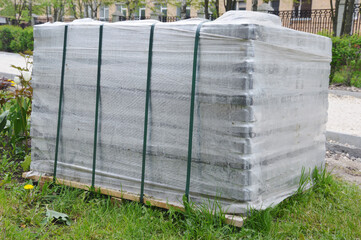 Packed pallets of paving slabs, ready for installation. City sidewalk repairs. Paving installation.