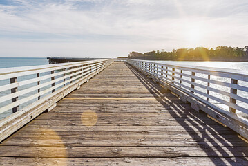 Fototapeta premium Coastal sunset landscape featuring the iconic pier at San Simeon, California