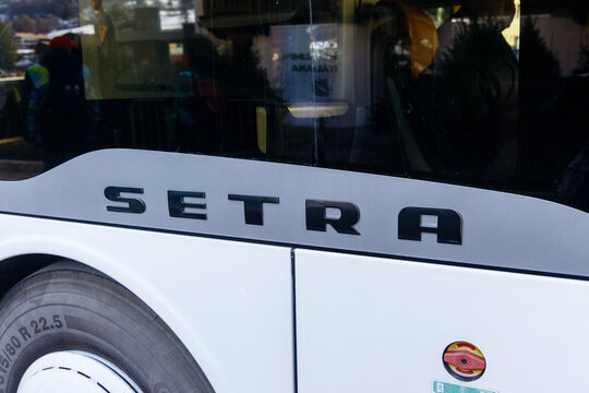 Cortina D Ampezzo, Italy - March 07, 2026: Setra bus close-up showing brand logo and tire details, parked in a location with blurred background of passengers and vehicles