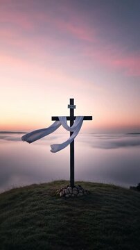 Wooden Christian cross with white cloth on a hill at sunrise for Easter resurrection morning