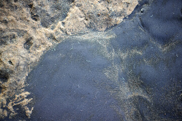 Close Up Black Sand And Volcanic Rock Texture On Coastal Beach Shoreline Abstract Pattern