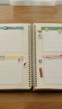 Vertical video: Pulling back cam after tight start, revealing planner coil, washi, stickers on wood