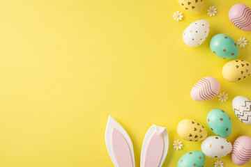 Happy Easter styled scene featuring pastel egg, bunny ear and daisy decorations arranged on a bright yellow background for seasonal greeting and holiday design © ActionGP