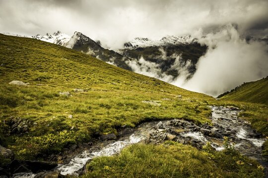 Mountain stream with mountain landscape and dramatic clouds, Sellrain, Innsbruck, Tyrol, Austria