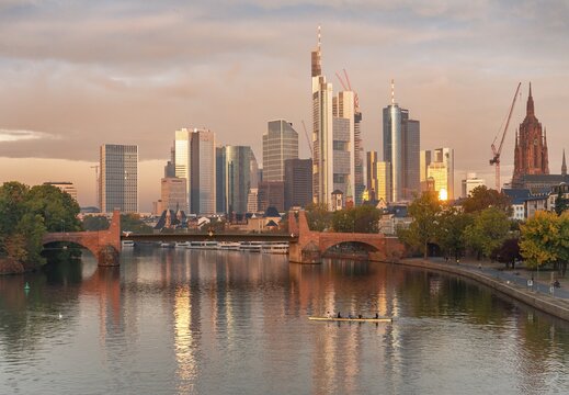 Skyline, skyscrapers in the banking district in the morning light, old bridge over the Main, rowers on the river, sunrise, autumn, Frankfurt am Main, Hesse, Germany