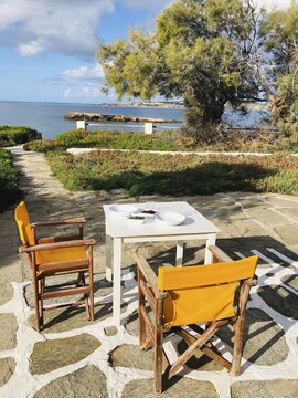 Terrace with sea view, table with olives and capers and two chairs, Paros, Cyclades, Greece