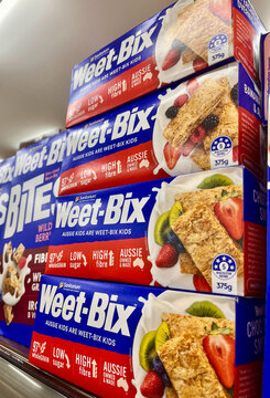 Bali, Indonesia - March, 5, 2026: Boxes of Weet-Bix cereal stacked on a grocery store shelf. The packaging features vibrant blue colors with images of fruits.