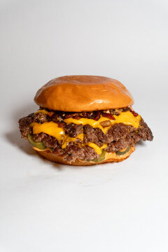 Classic double smash cheeseburger with pickles and special sauce on a toasted brioche bun isolated