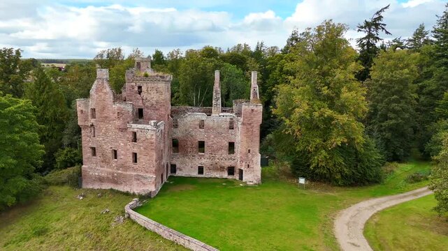 Stunning wide-angle drone footage of Redcastle, a medieval ruin in the Black Isle, Inverness, Scotland, overlooking the scenic Beauly Firth coastline.