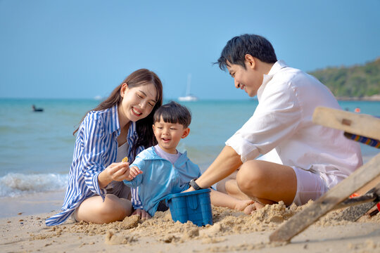 Multigenerational Asian family enjoying summer beach vacation, playing and relaxing together.