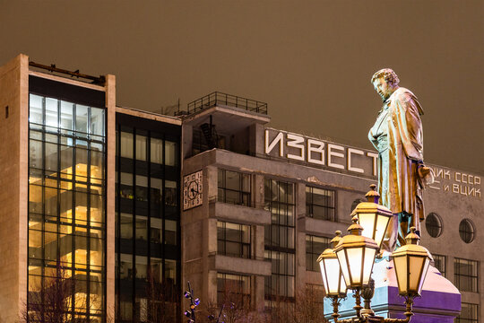 Moscow, Russia - January 7, 2026: Monument to Alexander Pushkin on Pushkinskaya Square and building of Izvestia newspaper in background in winter night