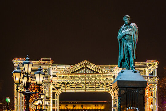 Moscow, Russia - January 7, 2026: front view of Alexander Pushkin Statue on Pushkinskaya Square and christmas decor in background in winter night