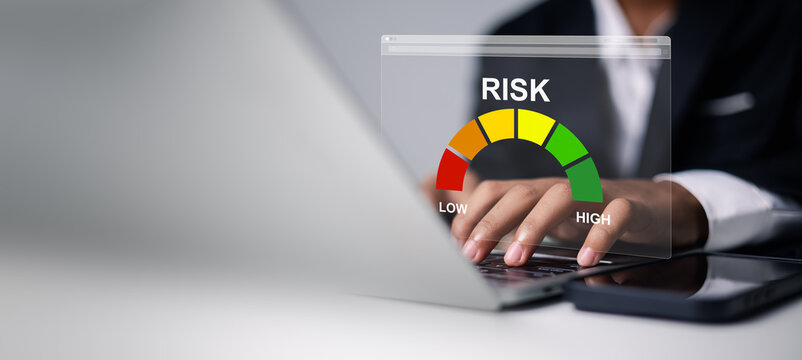 Businessman hands using laptop with virtual risk assessment gauge meter. Concept of financial risk management, credit score analysis, insurance evaluation, and business strategic decision making.