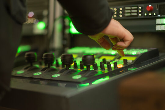 Professional engineer hand on video switcher control panel in news studio with copy space