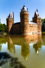 Obraz premium Beersel Castle. The outer walls and towers of the medieval castle are reflected in the moat. Beersel Castle, Flemish Brabant, Belgium