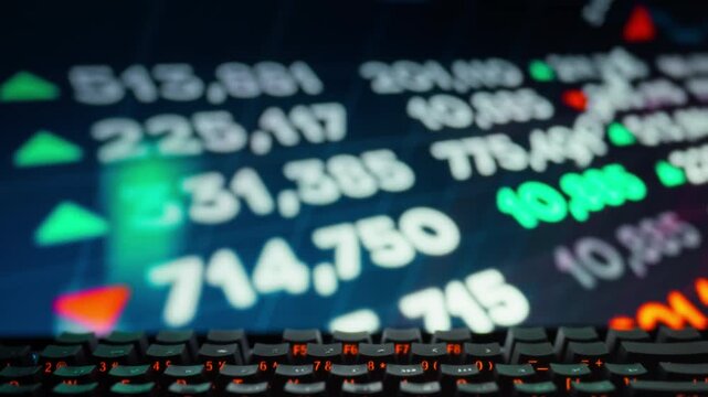 A trader closely monitors the stock screen on the monitor, tracking real-time changes in finance market prices, stocks, currencies, and indices quotes