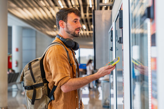 Male traveler making digital payment at airport
