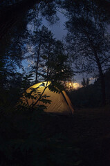 A tourist tent at night illuminated from the inside.