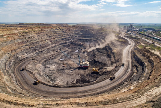 A large open-pit coal mine for fossil fuel extraction. A large coal deposit is mined using excavators.