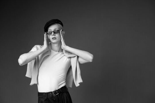 Black and white studio photo of a man with make up and sunglasses