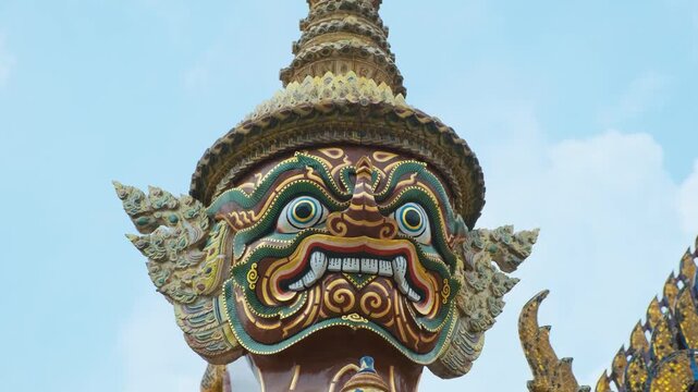 Close up of Yaksha guardian demon head statue at Wat Phra Kaew, Temple of the Emerald Buddha, the most sacred Buddhist temple located inside Grand Palace, Bangkok, Thailand