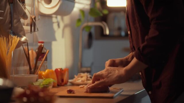A man's hands skillfully cut raw meat into manageable pieces to prepare a roast dish for dinner, transitioning from a day of work to a warm evening of braised or possibly fried meat delights