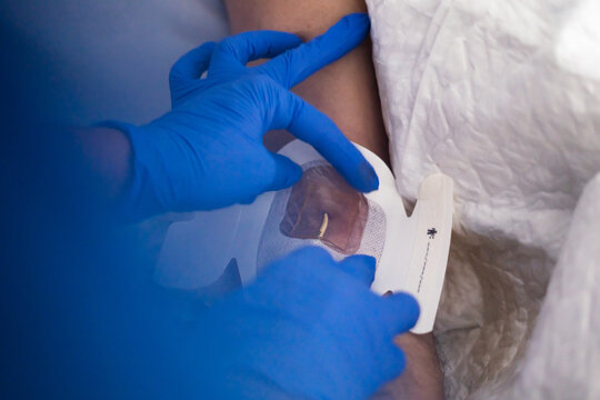 Healthcare professional changing picc line dressing on patient arm