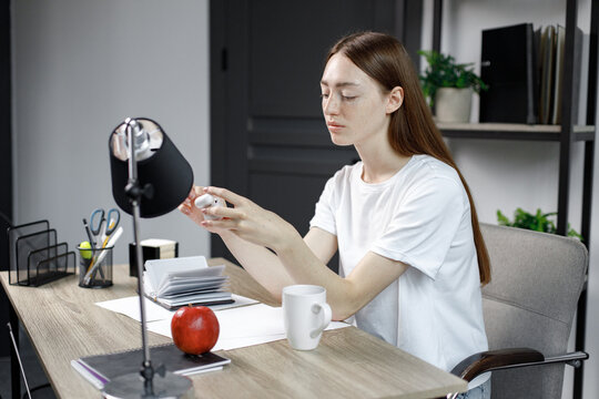 Portrait of a pretty young woman studying while sitting at the table